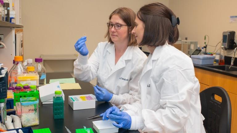 A student and professor review a slide