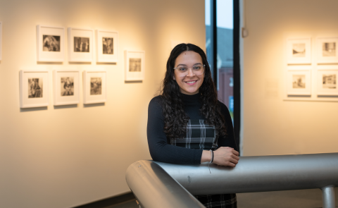 Portrait of Rhetta Vega against the walls of the UNE Art Gallery